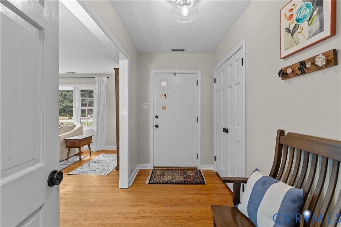 6956 Old Westham Road, Stratford Hills/Cherokee Road, Richmond, VA 23225 Foyer featuring wood-finish flooring, a six-panel entry door, a double-door coat closet, and a ceiling-mounted glass globe fixture