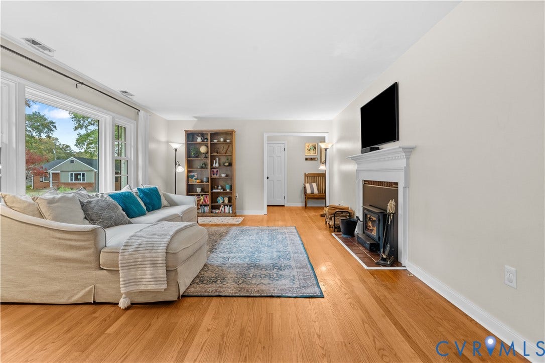 6956 Old Westham Road, Stratford Hills/Cherokee Road, Richmond, VA 23225 Living area featuring wood-finish flooring, a wood-burning fireplace with a white mantel, and large picture windows
