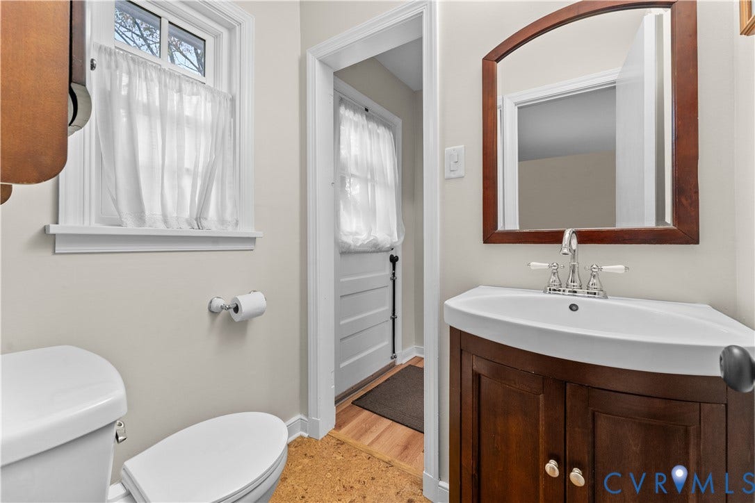 6956 Old Westham Road, Stratford Hills/Cherokee Road, Richmond, VA 23225 Vanity featuring a wood cabinet and integrated sink with polished metal hardware, crowned by a wooden-framed mirror