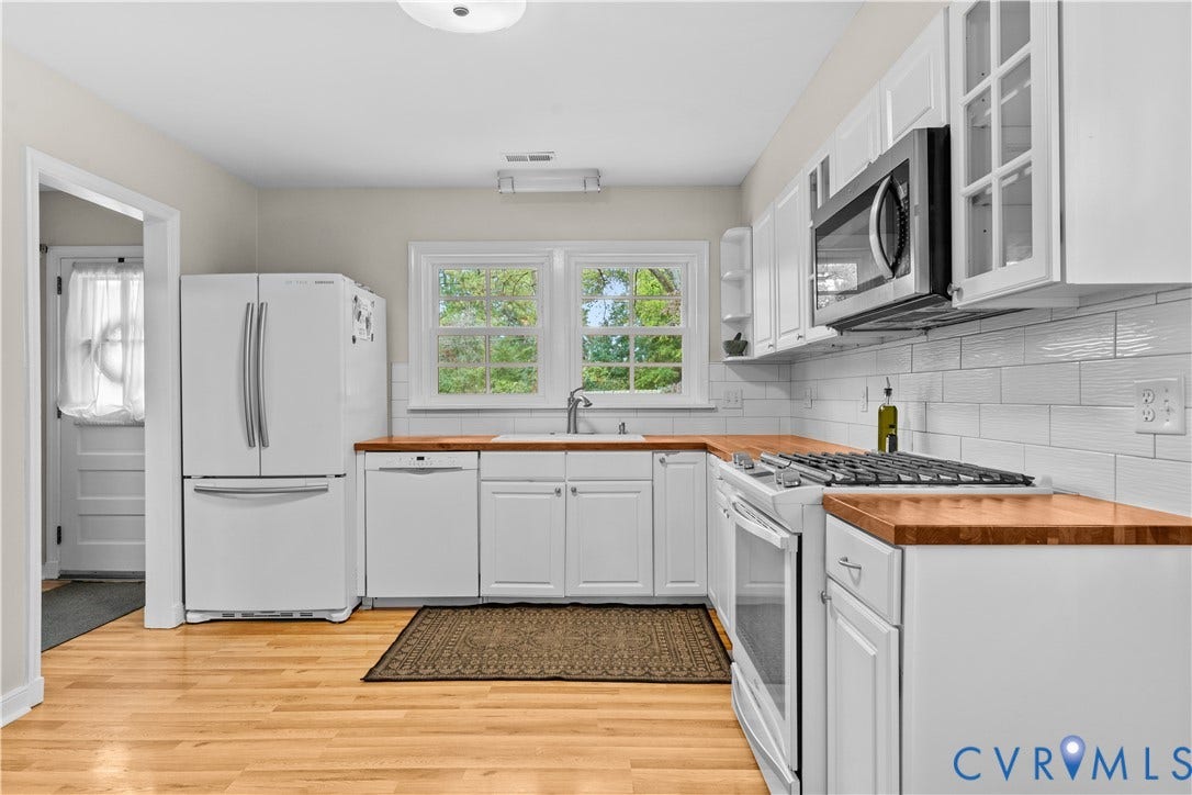 6956 Old Westham Road, Stratford Hills/Cherokee Road, Richmond, VA 23225 Kitchen featuring white shaker-style cabinetry, wood-finish countertops, subway tile backsplash, stainless steel microwave, and wood-finish flooring