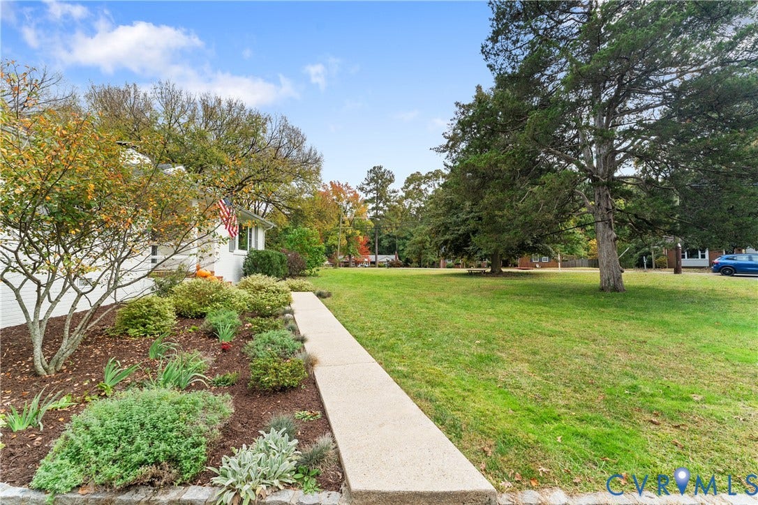 6956 Old Westham Road, Stratford Hills/Cherokee Road, Richmond, VA 23225 Expansive lawn featuring mature trees, concrete walkway, and landscaped garden beds with wood mulch