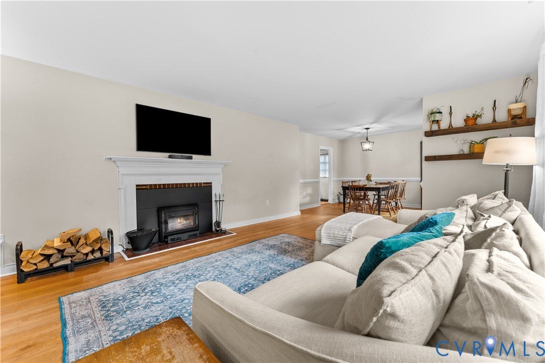 6956 Old Westham Road, Stratford Hills/Cherokee Road, Richmond, VA 23225 Fireplace with a classic white mantel, wood-finish flooring, and natural wood floating wall shelves