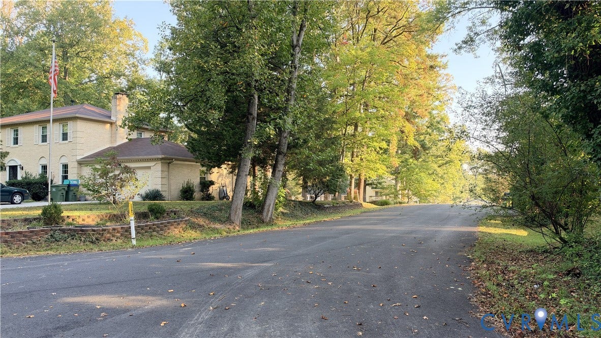 18428 Cedar Drive, Cedar Dr, Triangle, VA 22172 Two-story residence featuring light-toned masonry exterior, attached garage, and mature trees situated on a paved road
