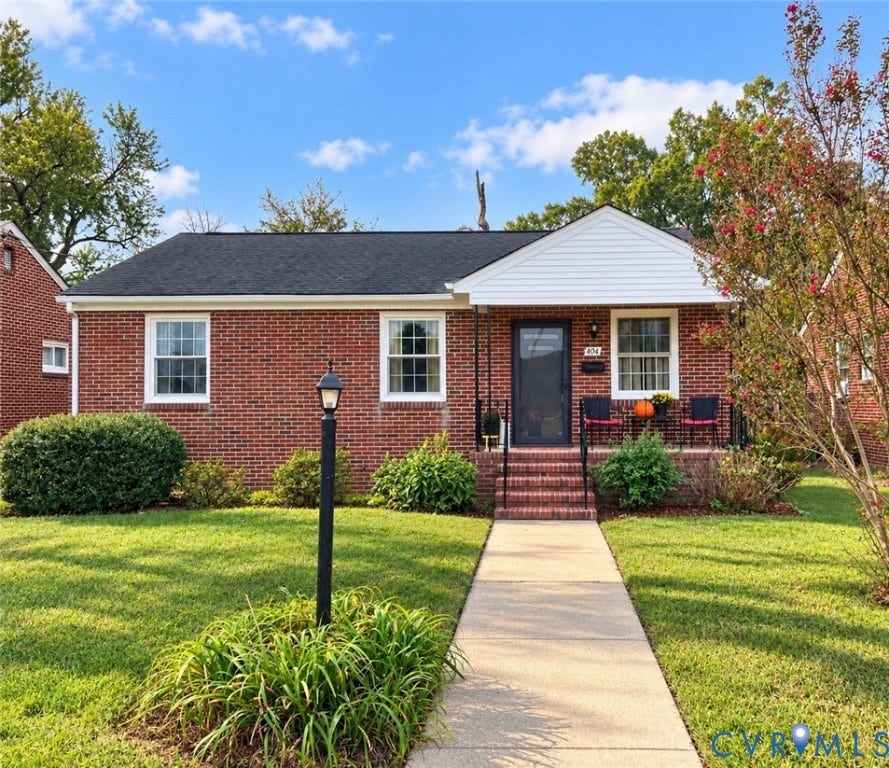 404 Ivey Avenue, Woodlawn, Colonial Heights, VA 23834 Single-story brick exterior featuring a white gable-front entry, multi-pane windows, a concrete walkway, and a brick staircase