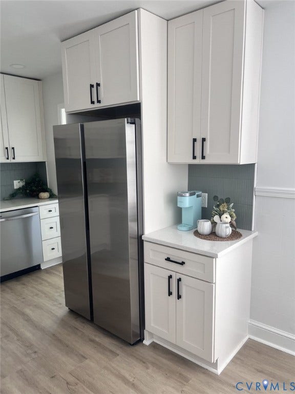 404 Ivey Avenue, Woodlawn, Colonial Heights, VA 23834 White shaker-style cabinetry with matte black hardware, stainless steel refrigerator, light-toned quartz countertops, and vertical tiled backsplash