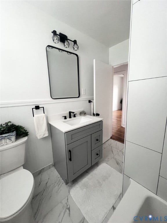 404 Ivey Avenue, Woodlawn, Colonial Heights, VA 23834 Grey vanity with a white countertop and undermount sink, marble-patterned tile flooring, rectangular mirror with a black frame, and matte black plumbing fixtures