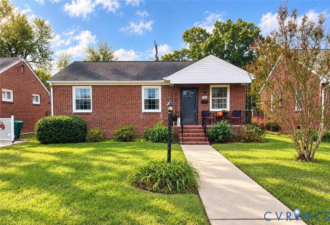 404 Ivey Avenue, Woodlawn, Colonial Heights, VA 23834 Classic brick exterior featuring a covered front porch, a central entryway, a concrete walkway, and a landscaped front lawn