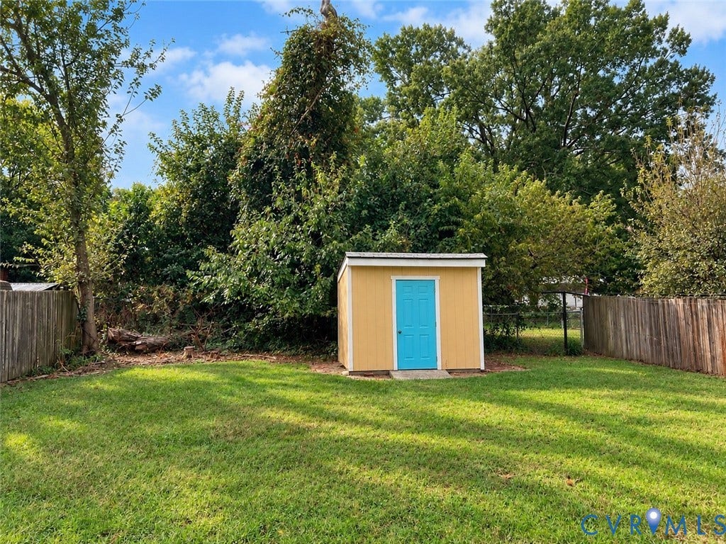 404 Ivey Avenue, Woodlawn, Colonial Heights, VA 23834 Backyard featuring a standalone storage structure with a shed-style roof, wood fencing, and mature trees