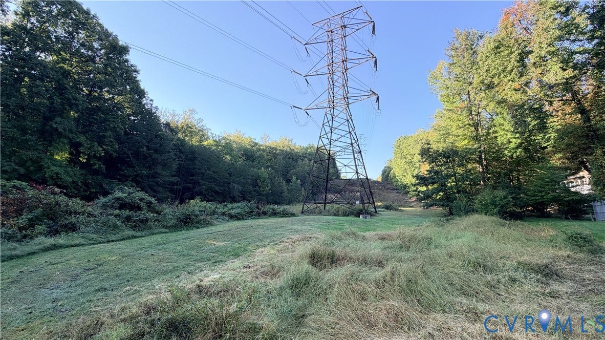 Open grassy lot surrounded by mature trees