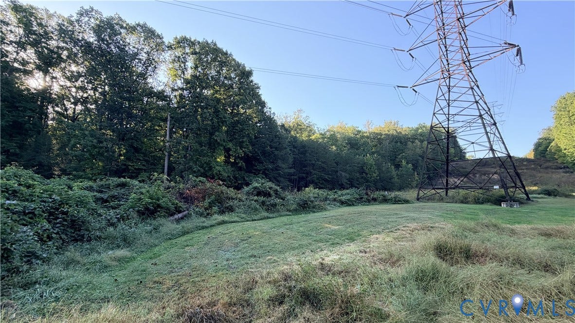 Open lot featuring expansive lawn area and mature trees