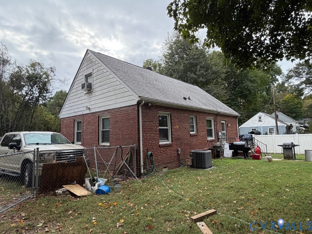 Brick exterior featuring gable roofline, white horizontal siding on the upper level, and a fenced yard