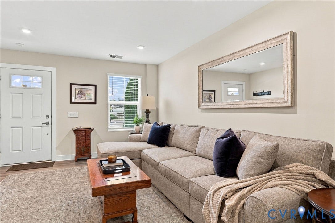 Neutral wall finishes, recessed ceiling lighting, a multi-pane glass entry door, and wood-finish flooring