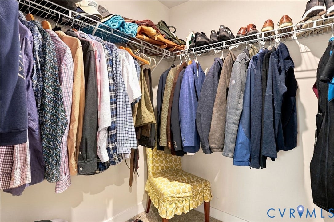 Walk-in closet featuring tiered wire shelving and integrated hanging rods