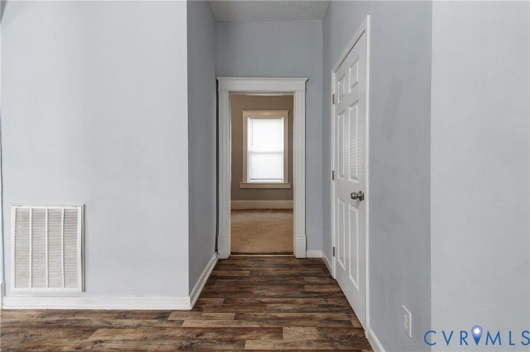 113 Spring Street, Pembroke, Petersburg, VA 23803 Wood-finish flooring, interior doorway with white-painted trim, and a six-panel door with a metallic knob