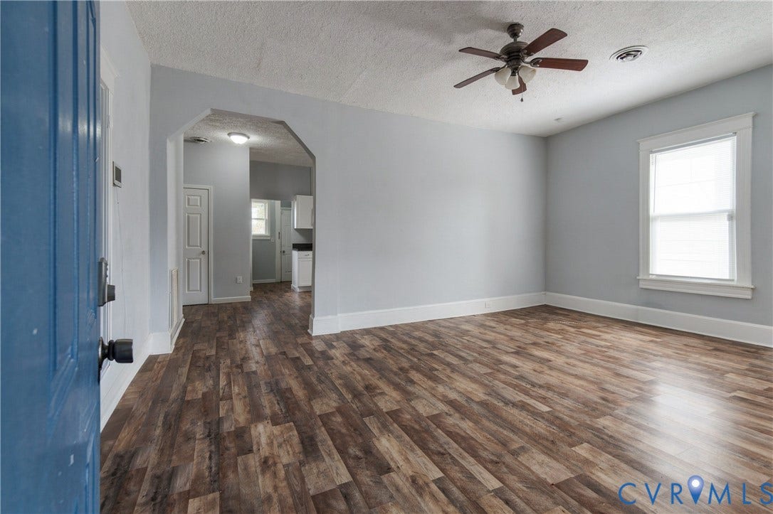 113 Spring Street, Pembroke, Petersburg, VA 23803 Living area featuring wood-finish flooring, a neutral color palette, a ceiling fan with integrated lighting, and a multi-pane window with custom trim