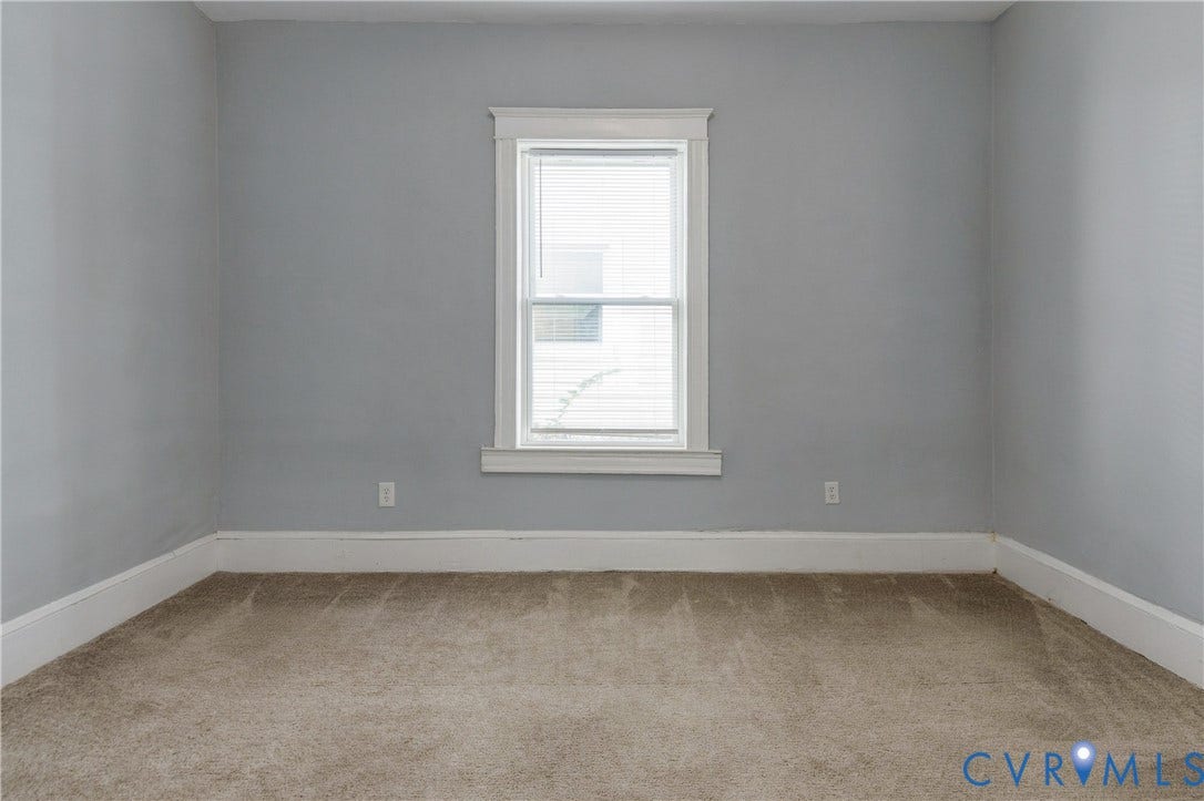 113 Spring Street, Pembroke, Petersburg, VA 23803 Neutral-toned wall paint, neutral carpeting, and a centrally positioned window featuring white trim and molding