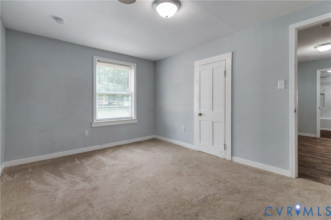 113 Spring Street, Pembroke, Petersburg, VA 23803 Neutral-toned interior room featuring wall-to-wall carpeting, a single-hung window, a multi-panel interior door, and a flush-mount ceiling light fixture