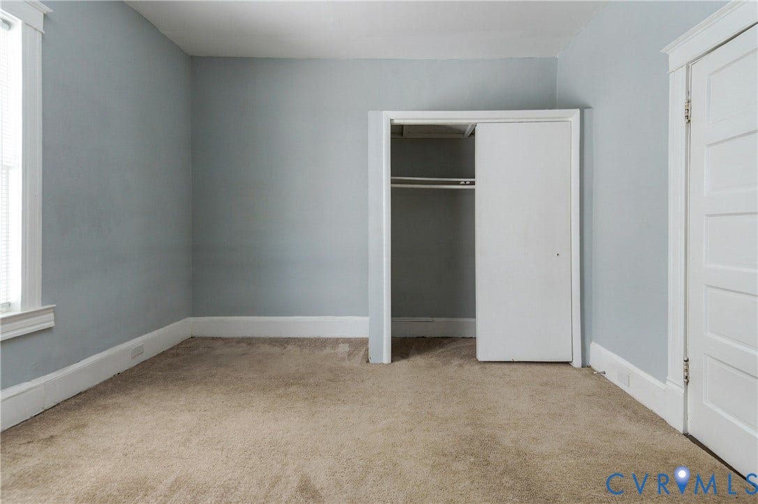 113 Spring Street, Pembroke, Petersburg, VA 23803 Interior room featuring neutral-toned carpeting, a built-in closet with sliding doors, and traditional multi-panel door and window casings