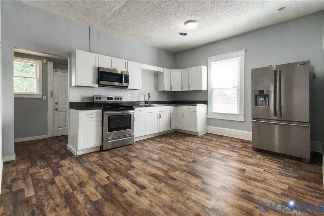 113 Spring Street, Pembroke, Petersburg, VA 23803 Kitchen featuring white shaker-style cabinetry, dark stone-finish countertops, stainless steel appliances, and wood-finish flooring