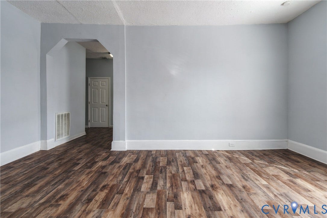 113 Spring Street, Pembroke, Petersburg, VA 23803 Interior space featuring wood-finish flooring, neutral wall paint, and a decorative arched doorway