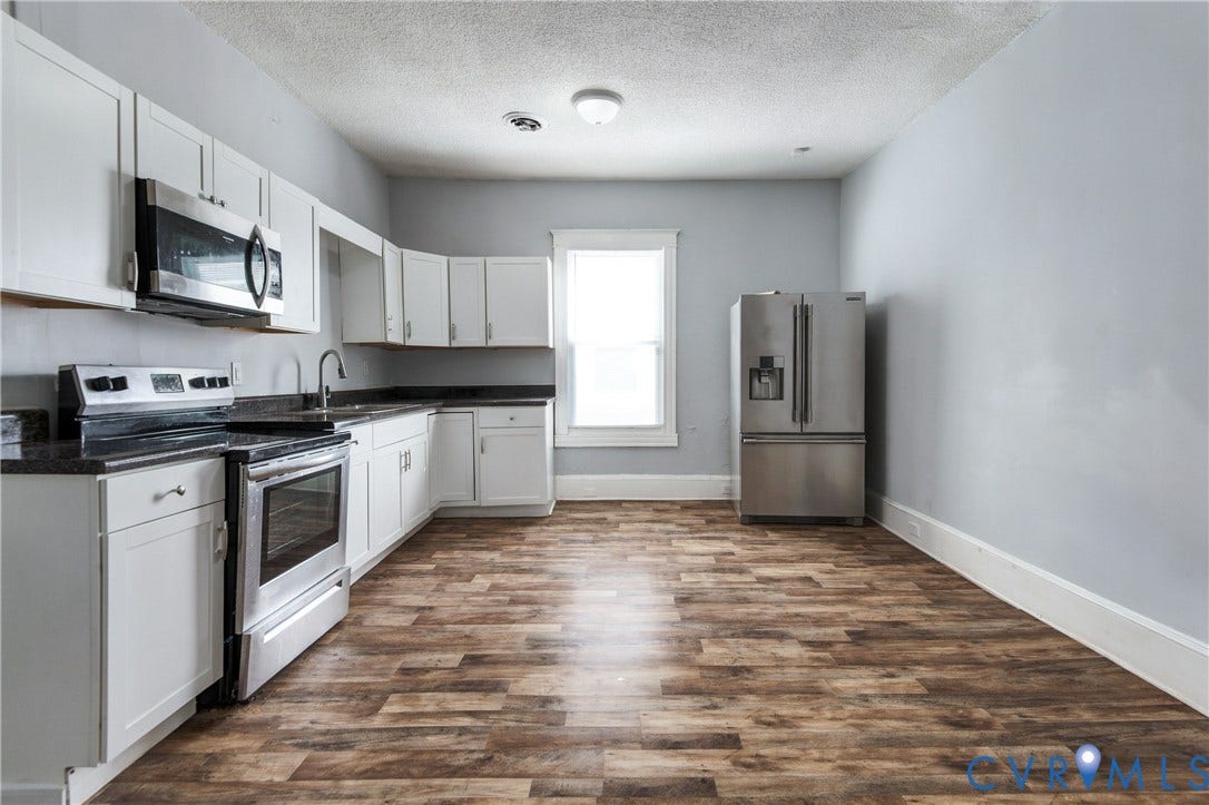 113 Spring Street, Pembroke, Petersburg, VA 23803 Kitchen featuring white shaker-style cabinetry, dark stone-finish countertops, stainless steel appliances, wood-finish flooring, and a single window