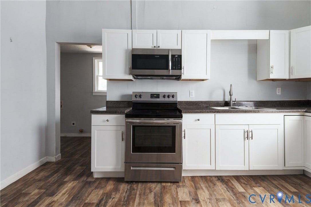 113 Spring Street, Pembroke, Petersburg, VA 23803 Kitchen featuring white cabinetry, dark stone-finish countertops, stainless steel appliances, and wood-finish flooring