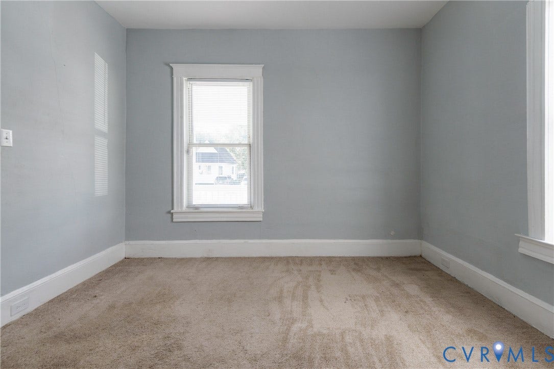 113 Spring Street, Pembroke, Petersburg, VA 23803 Neutral-toned interior space featuring light grey wall paint, plush carpeting, dual double-hung windows, and white window casing