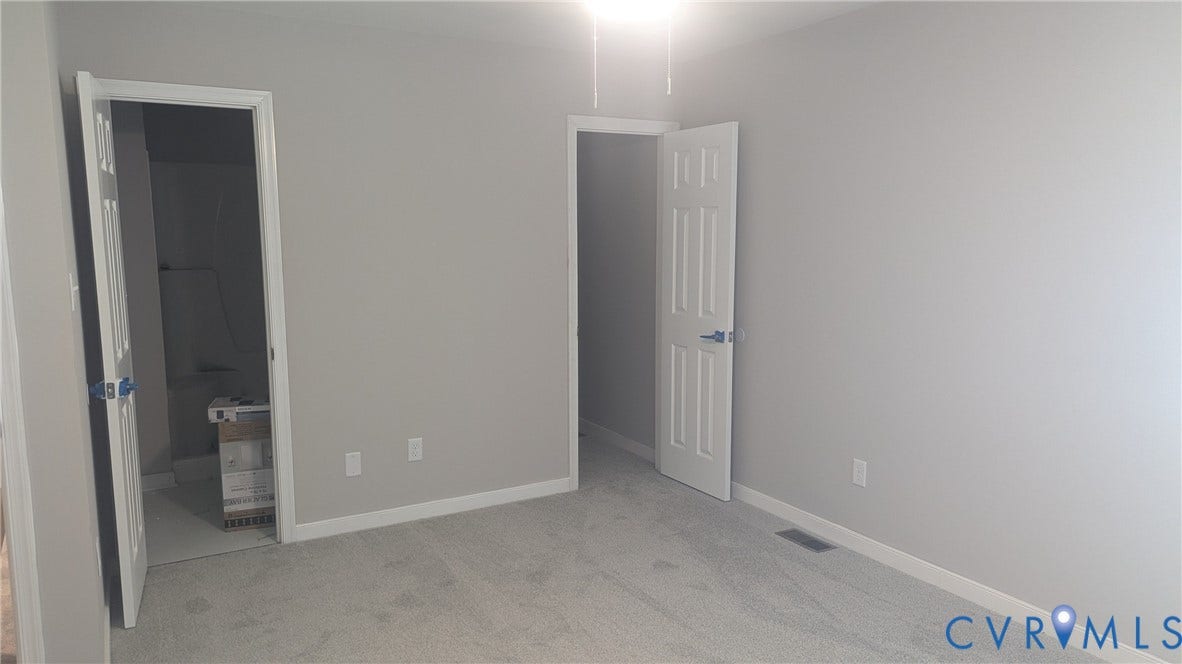 3006 Plumtree Street, South Chesterfield, VA 23834 Neutral-toned interior room featuring plush wall-to-wall carpeting, crisp white six-panel doors, and a ceiling-mounted light fixture