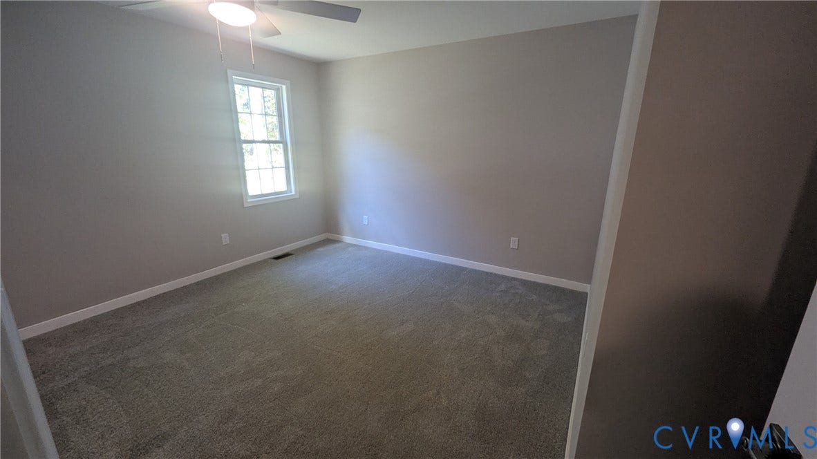 3006 Plumtree Street, South Chesterfield, VA 23834 Neutral-toned interior featuring wall-to-wall carpeting, a multi-pane window, and a ceiling-mounted light fixture with a fan