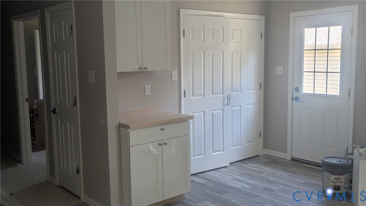 3006 Plumtree Street, South Chesterfield, VA 23834 White shaker-style cabinetry, wood-finish countertop, wood-finish flooring, six-panel interior doors, and exterior door with a multi-pane glass insert