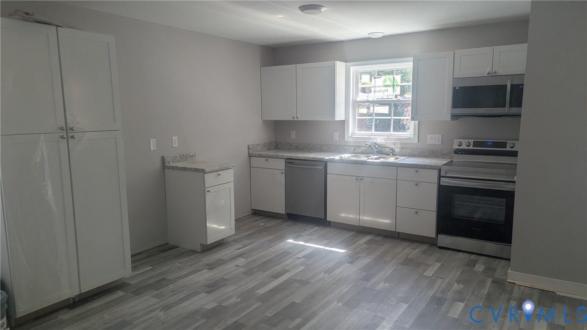3006 Plumtree Street, South Chesterfield, VA 23834 Kitchen featuring white shaker-style cabinetry, speckled stone-finish countertops, stainless steel appliances, and grey wood-finish flooring