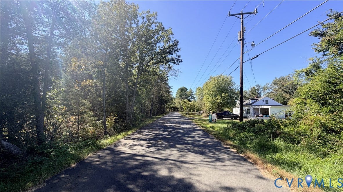13200 Farmview Road, Farmveiw Rd, Triangle, VA 20181 Asphalt roadway bordered by mature deciduous trees and native vegetation