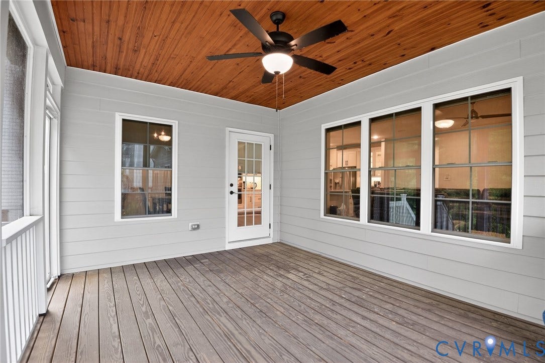 Covered porch featuring a wood-plank ceiling, ceiling fan with integrated lighting, horizontal lap siding, multi-pane windows, and a paneled glass door