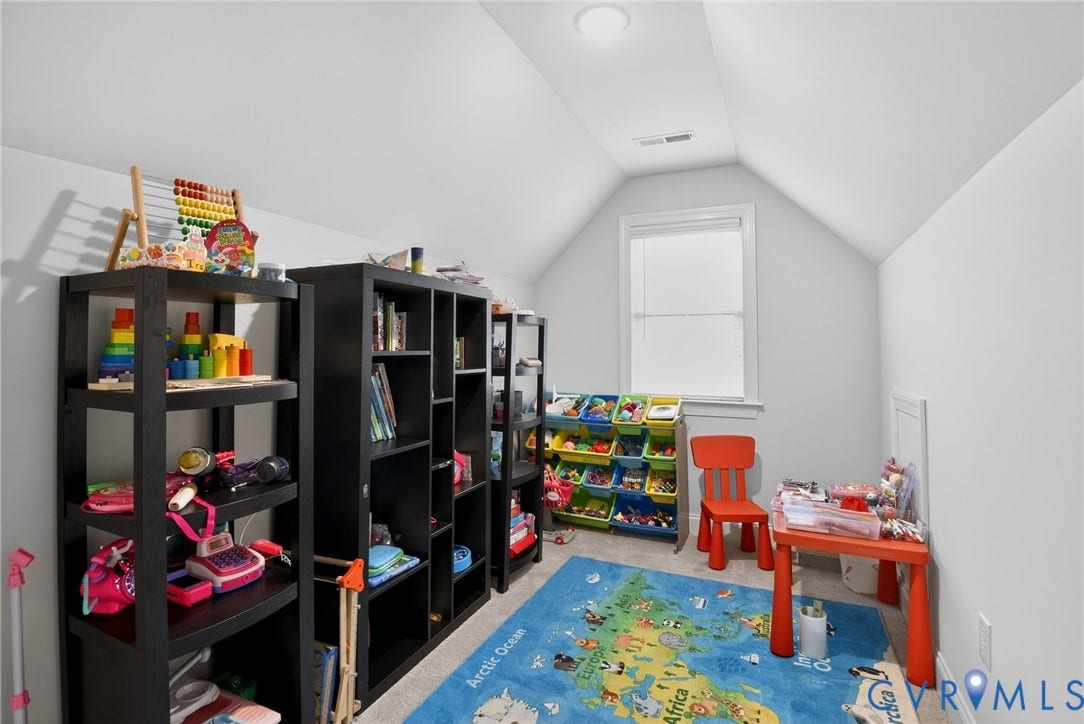 Vaulted ceilings and wall-to-wall carpeting featuring a single window with white trim