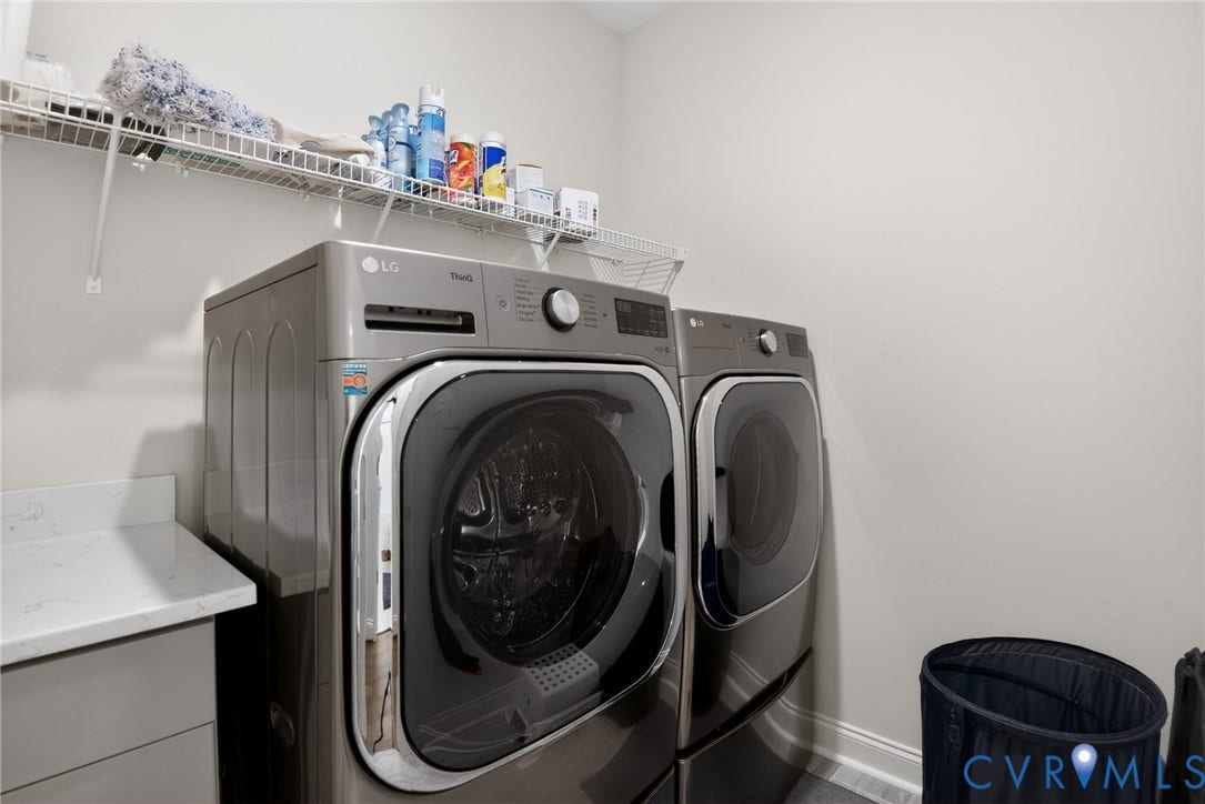 Utility area featuring built-in cabinetry with a stone countertop and wall-mounted wire shelving