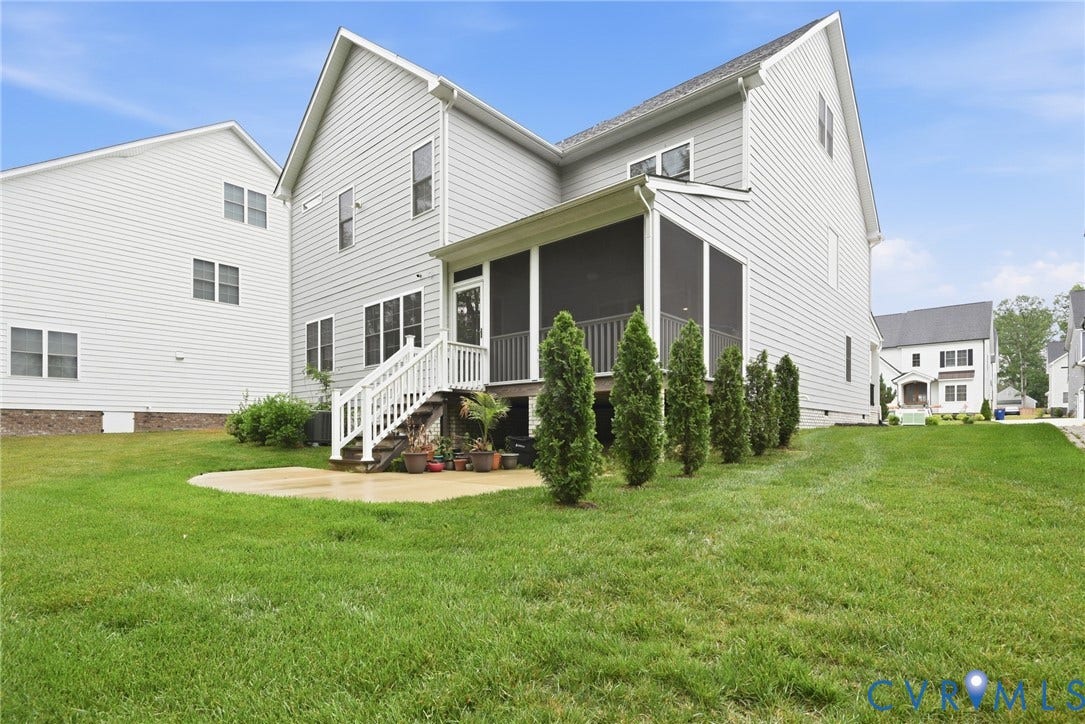 Multi-level exterior featuring light-toned horizontal siding, a screened-in porch with white railing, and a concrete patio