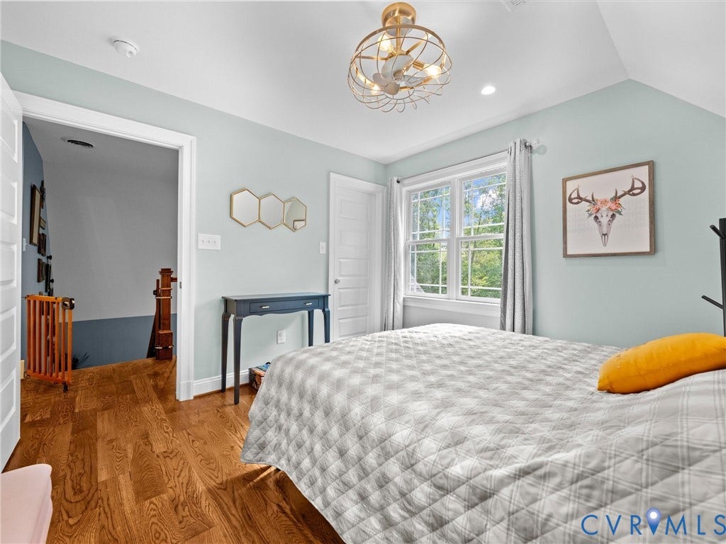 9877 Swinging Bridge Road, Taylors Grove Estates, Quinton, VA 23141 This spacious upper-level bedroom features beautiful hardwood floors, a ceiling fan, a generous walk-in closet, and large windows that fill the room with natural light while offering peaceful views of the surrounding countryside.
