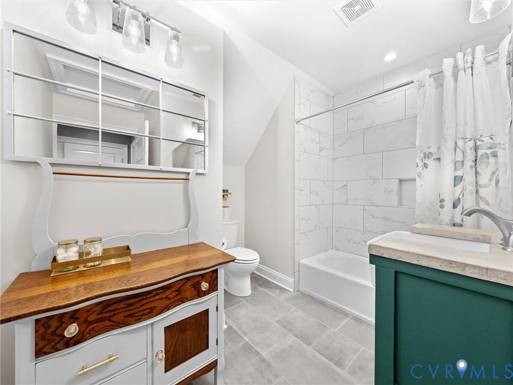 9877 Swinging Bridge Road, Taylors Grove Estates, Quinton, VA 23141 The spacious upper-level hall bath features a custom-made single-sink vanity, tile flooring, and a tub/shower combination with a tile surround.