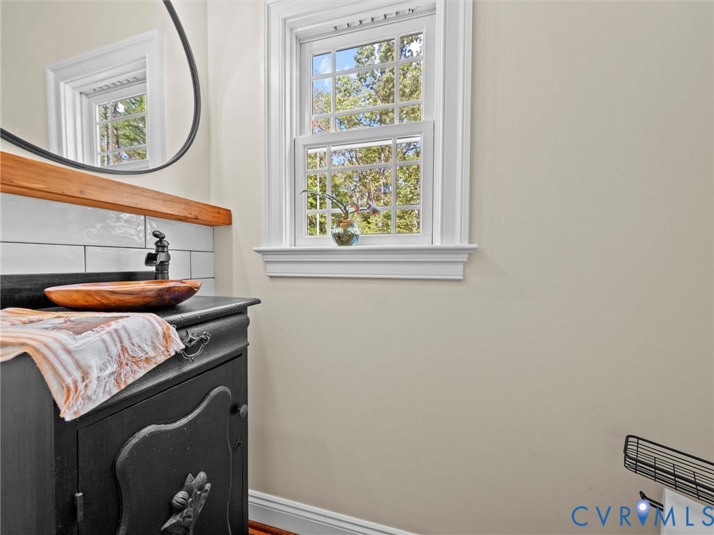 9877 Swinging Bridge Road, Taylors Grove Estates, Quinton, VA 23141 The charming first-floor half bath features a custom-built vanity, stylish fixtures, and natural light, adding a touch of character and convenience for guests.