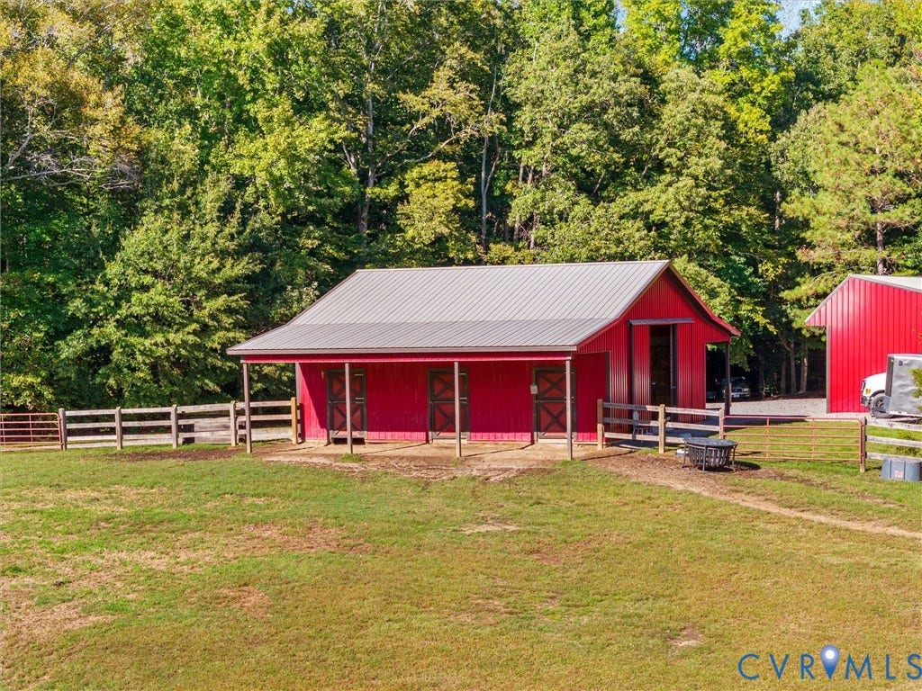 9877 Swinging Bridge Road, Taylors Grove Estates, Quinton, VA 23141 The charming 3-stall horse barn features a tack room, hay and storage area, and spacious 8-foot covered porches. Surrounded by beautiful fenced pastures and mature trees, this thoughtfully designed barn offers convenience, functionality, and a picturesque setting for your horses!