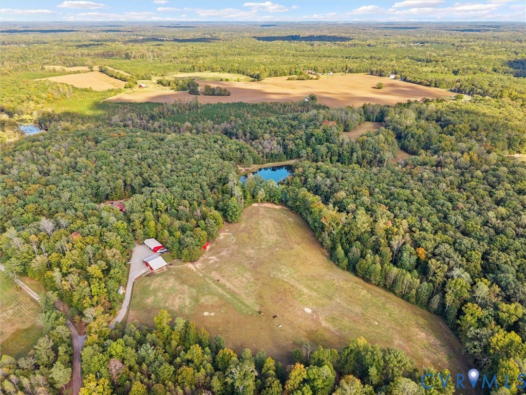 9877 Swinging Bridge Road, Taylors Grove Estates, Quinton, VA 23141 A breathtaking aerial view showcases the natural beauty and privacy of The Little Red Homestead! Spanning approximately 26.7 acres, this exceptional property offers a picturesque blend of rolling pastures, mature woodlands, scenic riding trails, and a beautiful stocked pond. A rare opportunity to enjoy the space, serenity, and endless possibilities of country living!