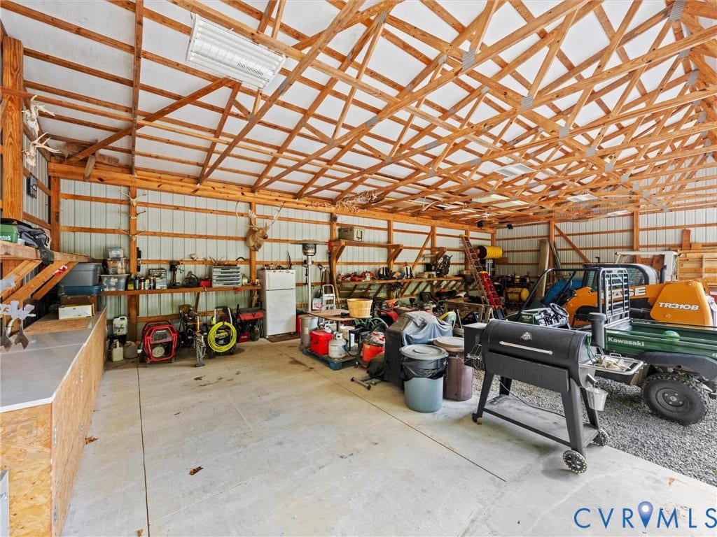 9877 Swinging Bridge Road, Taylors Grove Estates, Quinton, VA 23141 The spacious equipment barn offers ample room for tractors, farm machinery, tools, and workshop projects. Featuring exposed wood trusses, electricity, and a versatile open layout, this functional space is ideal for farm maintenance, equipment storage, and hobbies!