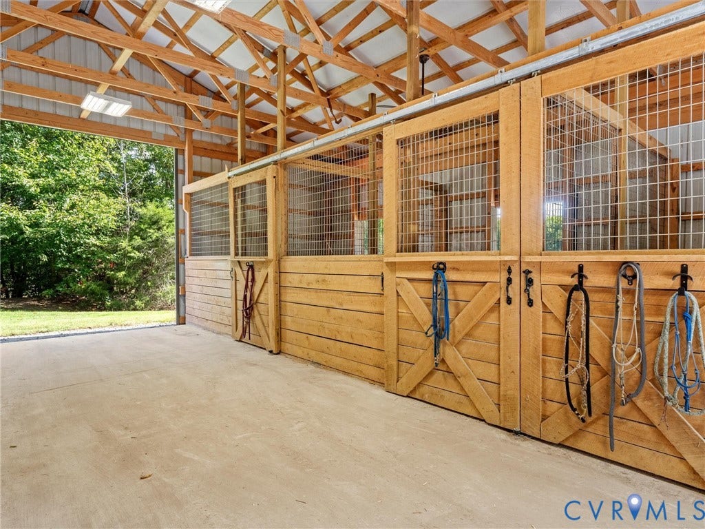 9877 Swinging Bridge Road, Taylors Grove Estates, Quinton, VA 23141 The well-designed 3-stall horse barn features spacious stalls with attractive wood fronts, sliding stall doors, and an open, airy center aisle. Exposed wood trusses and generous natural light create a bright, welcoming environment, while the convenient layout makes daily horse care a breeze!