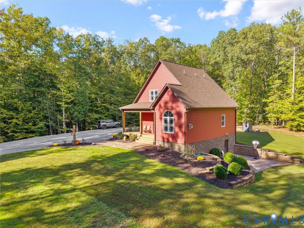 9877 Swinging Bridge Road, Taylors Grove Estates, Quinton, VA 23141 Beautiful tiered landscaping with stacked stone retaining walls, manicured planting beds, and lush green lawns enhances the home's charming exterior. Surrounded by mature trees, this picturesque setting offers a wonderful blend of natural beauty and thoughtful landscaping!
