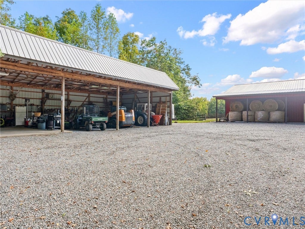 9877 Swinging Bridge Road, Taylors Grove Estates, Quinton, VA 23141 The spacious 4-bay equipment barn features electricity, with one bay offering a concrete floor. Perfect for storing tractors, farm equipment, trailers, and other essentials, with a generous gravel area providing convenient access and maneuverability!