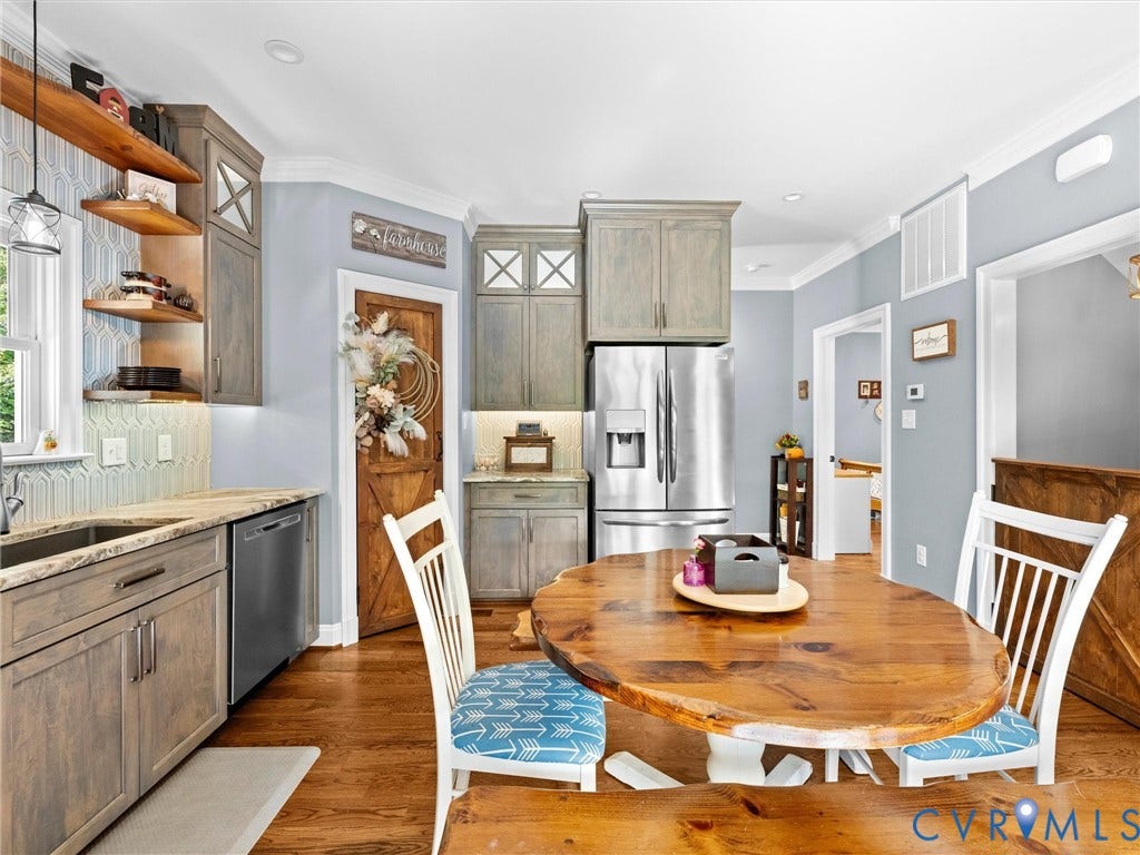 9877 Swinging Bridge Road, Taylors Grove Estates, Quinton, VA 23141 Another view of the beautiful custom kitchen showcases the granite countertops, stainless steel appliances, abundant cabinetry, and hardwood floors. A charming wood door leads to the spacious walk-in pantry featuring wood shelving for convenient storage and organization!