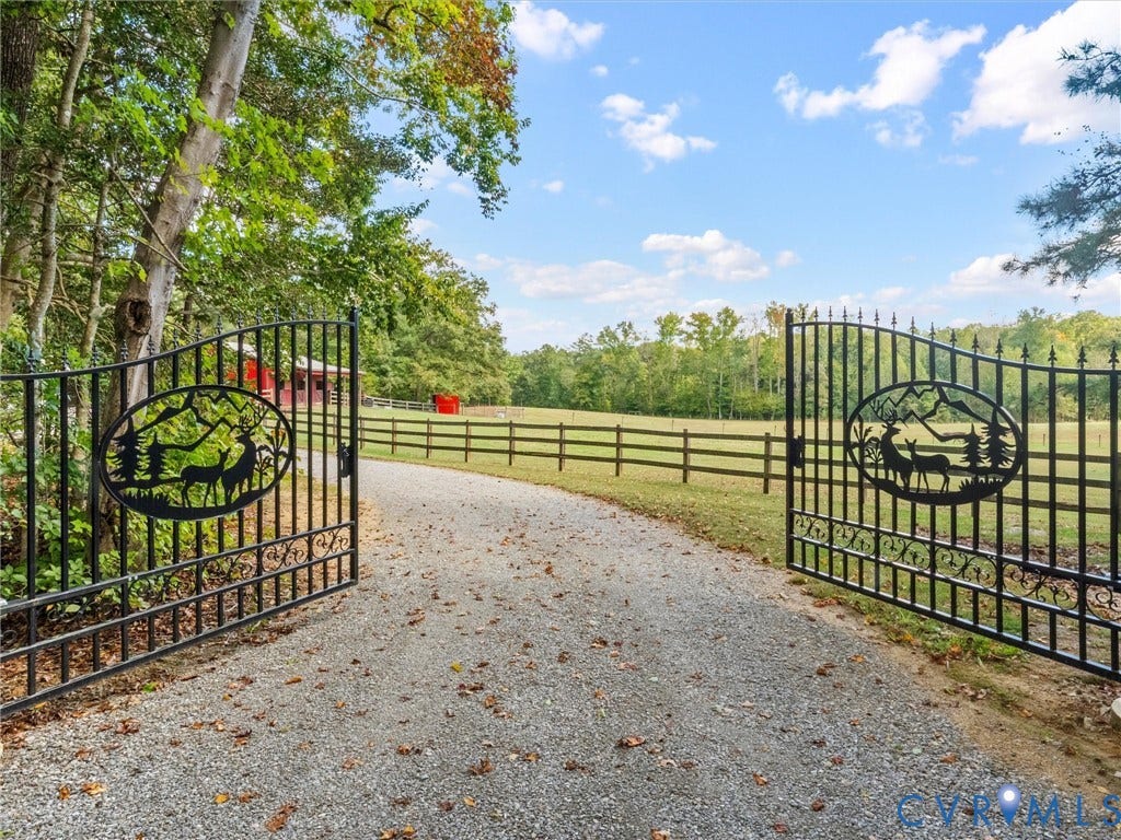 9877 Swinging Bridge Road, Taylors Grove Estates, Quinton, VA 23141 A beautiful entrance welcomes you to The Little Red Homestead! Elegant wrought iron gates with an automatic gate opener lead to a picturesque gravel driveway, framed by mature trees and scenic fenced pastures. A stunning first impression of this peaceful country retreat!