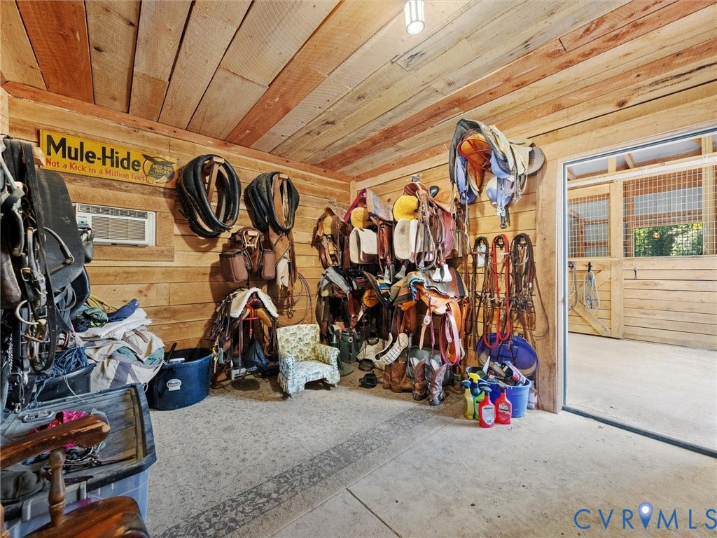 9877 Swinging Bridge Road, Taylors Grove Estates, Quinton, VA 23141 The spacious tack room features rustic wood walls and ceilings, ample storage for saddles, bridles, and riding equipment, and direct access to the center barn aisle for convenient tacking up and everyday horse care!