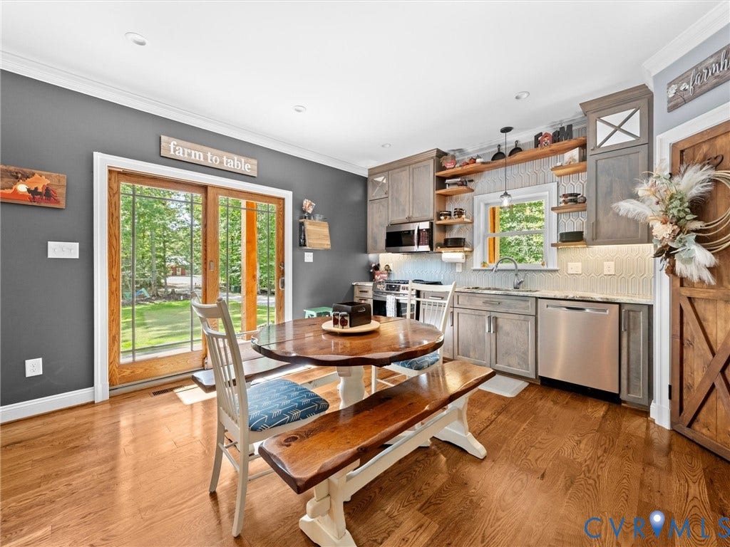 9877 Swinging Bridge Road, Taylors Grove Estates, Quinton, VA 23141 The beautiful custom kitchen features granite countertops, stainless steel appliances, a tile backsplash, and a spacious corner pantry with wood shelving. Gorgeous hardwood floors, generous cabinetry, and a welcoming dining area create the perfect space for everyday living and entertaining!
