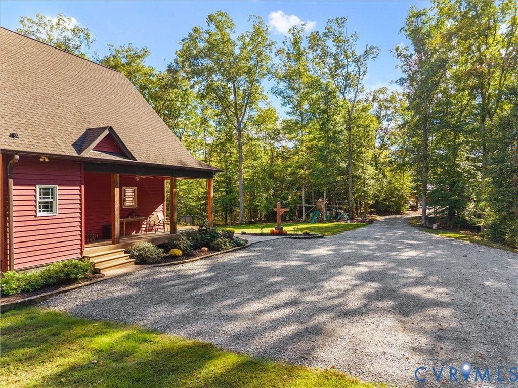 9877 Swinging Bridge Road, Taylors Grove Estates, Quinton, VA 23141 Convenient side entrance leads directly into the foyer, with a charming covered entry, attractive landscaping, and an expansive gravel parking area offering plenty of space for vehicles and guests.